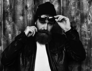 şapka ve gözlük kahverengi vintage ahşap studio arka plan üzerinde. Sakallı acımasız beyaz hipster gözlük