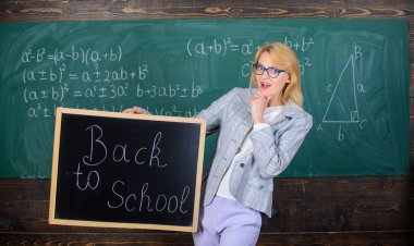 Yeni okul sezon başında. Öğretmen öğretim yılı ağırlamaktadır. Kadın öğretmen blackboard yazıt okula geri tutar. Bayan eğitimci sınıfta çalışmaya hazır mısın merak ediyor. Çalışmaya hazır mısın