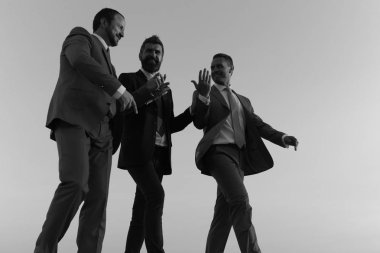 İş, başarı ve işbirliği kavramı. Şirket liderlerinin günbatımı gökyüzü arka plan üzerinde yürümek