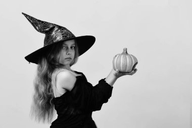 Cadı kostüm ve jack o fener çocuk. Kız sıcak sarı arka plan üzerinde izole oyma Turuncu kabak ile