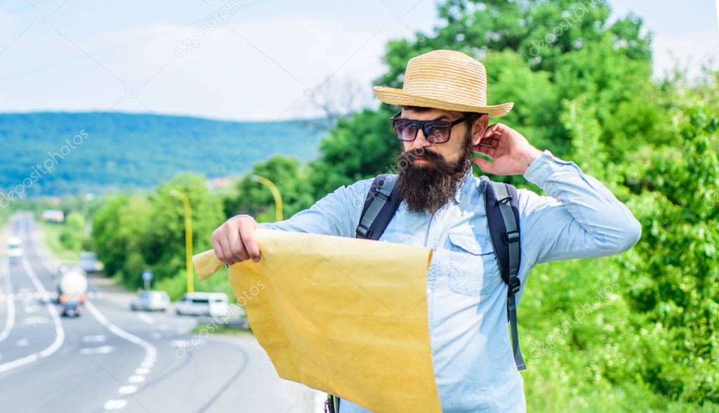 Pick up local map. Tourist backpacker looks at map choosing travel destination at road. Around the world. Find map large sheet of paper. Allow recognize enough details to walk somewhere if get lost