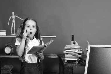 Geri okul ve çocukluk kavramına. Fikir olan kız öğrenci açık kitap onun sınıfta tutar.