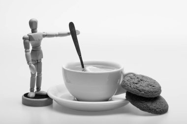 Fincan yeşil çay ve insansı oyuncak karıştırma. Limon dilimleri ve kaşık kürek gibi çayla.