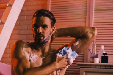 Banyo tuvalet malzemeleri ve arka plan merdivenlerde adam. Seksi şekilde sünger ile yıkama maço