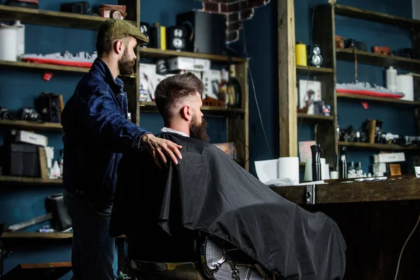 Hipster-Klient bekam neuen Haarschnitt. Friseur mit bärtigem Mann, der in den Spiegel schaut, Barbershop-Hintergrund. Haarschnitt-Konzept. Ergebnis der Kunden- und professionellen Meisterprüfung. Friseur fertig getrimmt — Stockfoto