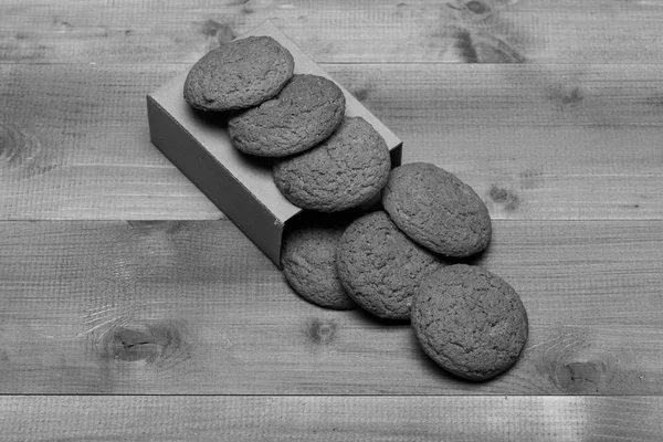 Kekse auf Karton auf grauem Holzgrund. süße Backwaren und leckere Snacks. Haferflockenkekse — Stockfoto