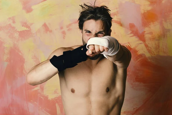 Concepto deportivo de defensa y taekwondo. Hombre con cara enojada y torso desnudo sobre fondo colorido . — Foto de Stock