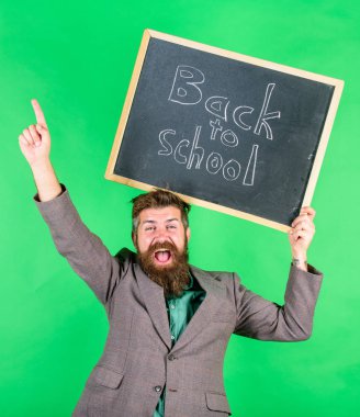 Okula geri özel teklif. Sakallı adam öğretmen blackboard yeşil arka plan üzerinde okul yazıt için geri tutar. Özel indirim indirim ve satış okul sezonu. Öğretmenler ve eğitimciler için teklif