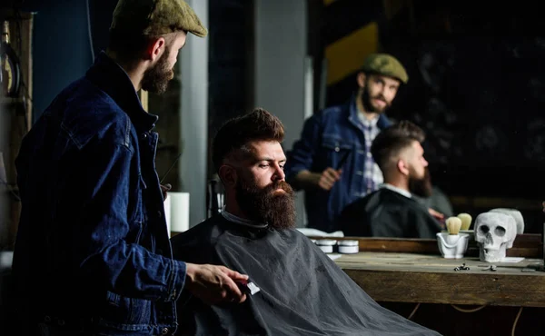 Il cliente hipster si e 'tagliato i capelli. Barbiere con tosatrice che si guarda allo specchio, sfondo barbiere. Risultato di controllo master professionale mentre il cliente siede sulla sedia. Barbiere fatto taglio di capelli. Concetto taglio di capelli — Foto Stock