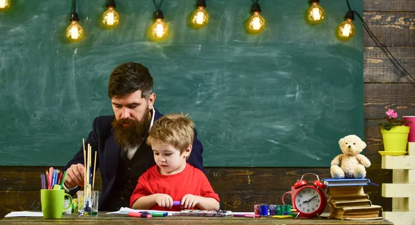 Ritning lektion koncept. Barn och lärare på upptagen ansikten måleri, teckning. Lärare med skägg, Pappa och lilla son i klassrummet när du ritar skapar, svarta tavlan på bakgrund — Stockfoto