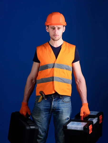 Profesionální opravář koncept. Dělník, údržbář, opravář, tvůrce na přísnou tvář nese tašky s profesionálními nástroji. Muž v helmu, přilbu drží nástrojů a kufr s spouštění nástroje, modrá — Stock fotografie