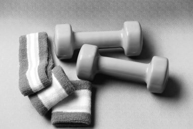 Shaping and fitness. Barbells near white and green hand band clipart