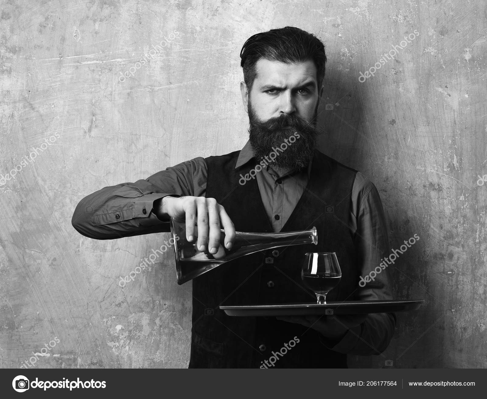 Man With Beard Holds Cognac On Beige Wall Background Service And