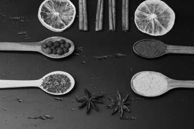 Baharatlar üzerinde koyu gri ahşap arka plan ayarlayın. Gıda sanat kavramı. Kırmızı biber, zerdeçal ve otlar ile tahta kaşıklar