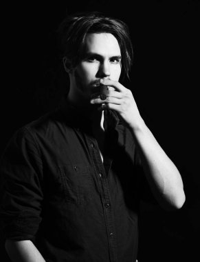 Ciddi sakallı adam puro içiyor.