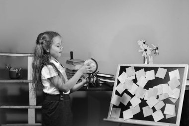 Geri okul ve çocukluk kavramına. Blackboard ile renkli yapışkan notlar tarafından kız duruyor