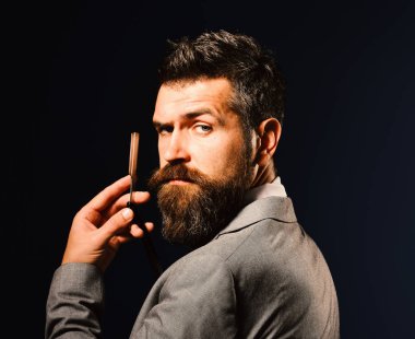 Uzun sakallı adam jilet yerine bıçak tutuyor. Berber dükkanı reklamı.
