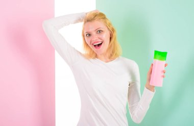 Uzman ipuçları inanılmaz saç elde etmek. Daha önce ısı styling saç korumak. Koruyucu ürün ilk önce uygulayın. Saç stil ipuçları. Kız sarışın şampuan şişesi tutar. Kadın güzellik ürün saç için gösterir