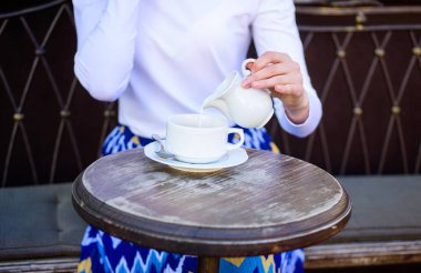 İpuçları sağlıklı kahve içmek için. El kadın siyah kahve açık hava kafe Teras için dökülen süt ekleyerek kapatın. Kupa americano ya da sade kahve ve süt ile sürahi. Süt ile daha iyi geliyor