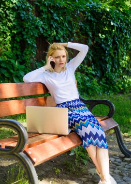 Teknolojileri hayat kolaylaşır. Kadın dizüstü bilgisayar ile açık havada çalışır. İş kadını park dizüstü smartphone ile çalışır. Kız akıllı telefon çağrı iş sorunu çözmek. İş kadını uzak sorunlarını çözme