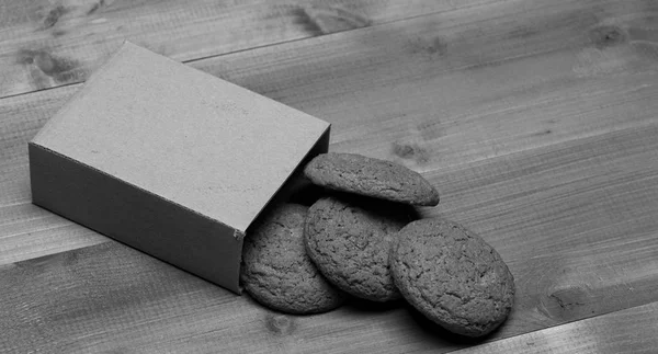 Kekse in Kartonschachtel auf grauem Holzgrund. süße Backwaren und leckere Snacks. Konzept für Backmahlzeiten. — Stockfoto