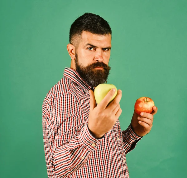 Αγρότης με αυστηρό πρόσωπο κρατά φρέσκα φρούτα. Ο τύπος παρουσιάζει συγκομιδή — Φωτογραφία Αρχείου