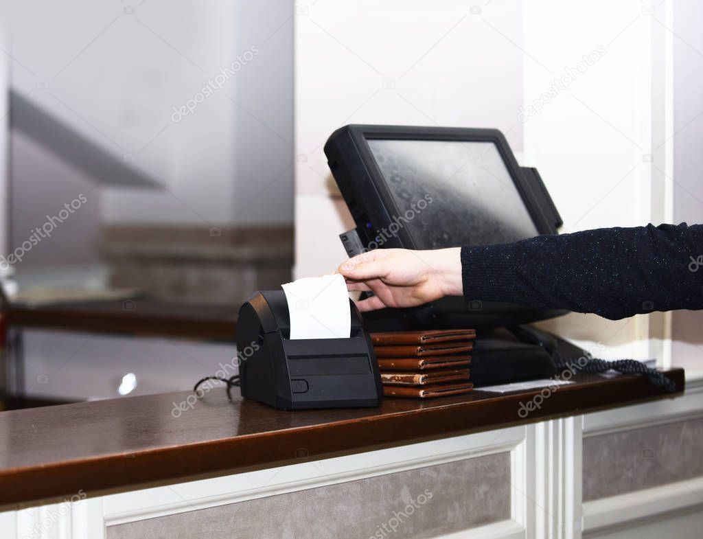 Cashier takes bill out of bill machine in restaurant