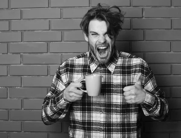 Tenant tasse bleue sur fond de mur de briques texturées, espace de copie. beau gars tenant tasse sur fond de mur de brique — Photo