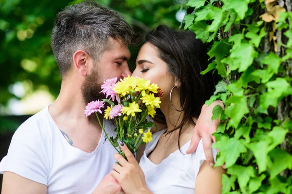Titkos romantikus csók. Szeretem a romantikus érzelmeket. Pillanatban az intimitás. Bouquet virágok mögé bújva szerelmes pár csók. Pár szerelem romantikus dátum természet háttér. Az ember szakállas csípő csókok barátnője — Stock Fotó