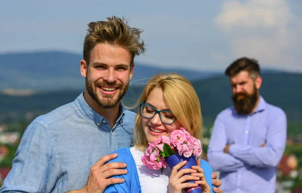 Couple amoureux sortir ensemble tandis que l "homme barbu jaloux regarder femme le tromper avec amant. Amoureux câlins flirt en plein air relations romantiques. Couple romantique amoureux de date bouquet de fleurs. Concept d'infidélité — Photo