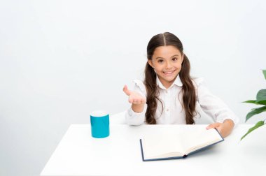 Bunu biliyor muydun. Okuma ders kitabı. Kız çocuk sit tablo beyaz arka planı süre kitap okur. Kız öğrenci eğitim okuma kitabı. Çocuk kız okul üniforması mutlu yüz ders kitabı okuyun. Bilgi hakkında heyecanlı