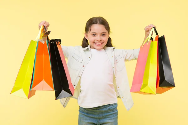 Mejores descuentos y códigos promocionales. Volver a la temporada escolar un buen momento para enseñar presupuesto básico a los niños. La chica lleva bolsas de compras. Prepárese para la temporada escolar comprar artículos de papelería ropa de antemano —  Fotos de Stock