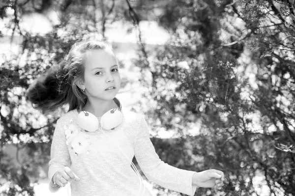 Kindertänzerin mit langen fliegenden Haaren. Mädchen tanzen zu Musik im Sommerpark. Kleine Kinder genießen Musik im Freien mit Kopfhörern. Melodieklang und mp3. Sommerspaß und -freude — Stockfoto