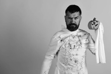 Cadılar Bayramı karakter beyaz hayalet kostümü. Adam sarı arka plan, kopya alanı üzerinde katı yüz ifadesi ile