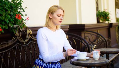 Huzurlu kahve molası. Kadın sakin yüz zarif açık havada içki kafe teras vardır. Kız içki kahve her sabah geleneği olarak aynı yerde. İyi kahve sabah fincan bana enerji giderleri sağlar