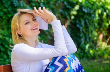 En iyi kitap şimdiye kadar. Bayan güzel kitap kurdu rüya gibi okumak kitap açık havada güneşli gün. Kadın rüya gibi gülümseyen kitap okumak bahçesinde. Kız oturup kitap ile yeşil doğa arka plan tezgah rahatlatıcı