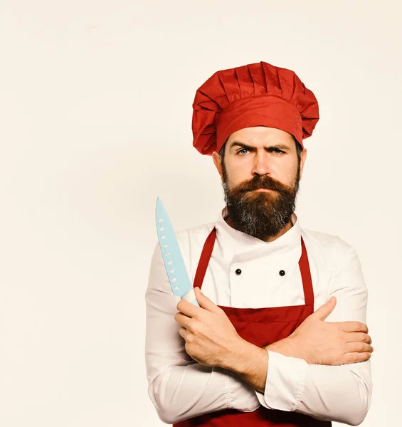 Het koken van apparatuur en keuken concept. Koken met ernstige gezicht in Bourgondië schort en chef-kok hoed. — Stockfoto