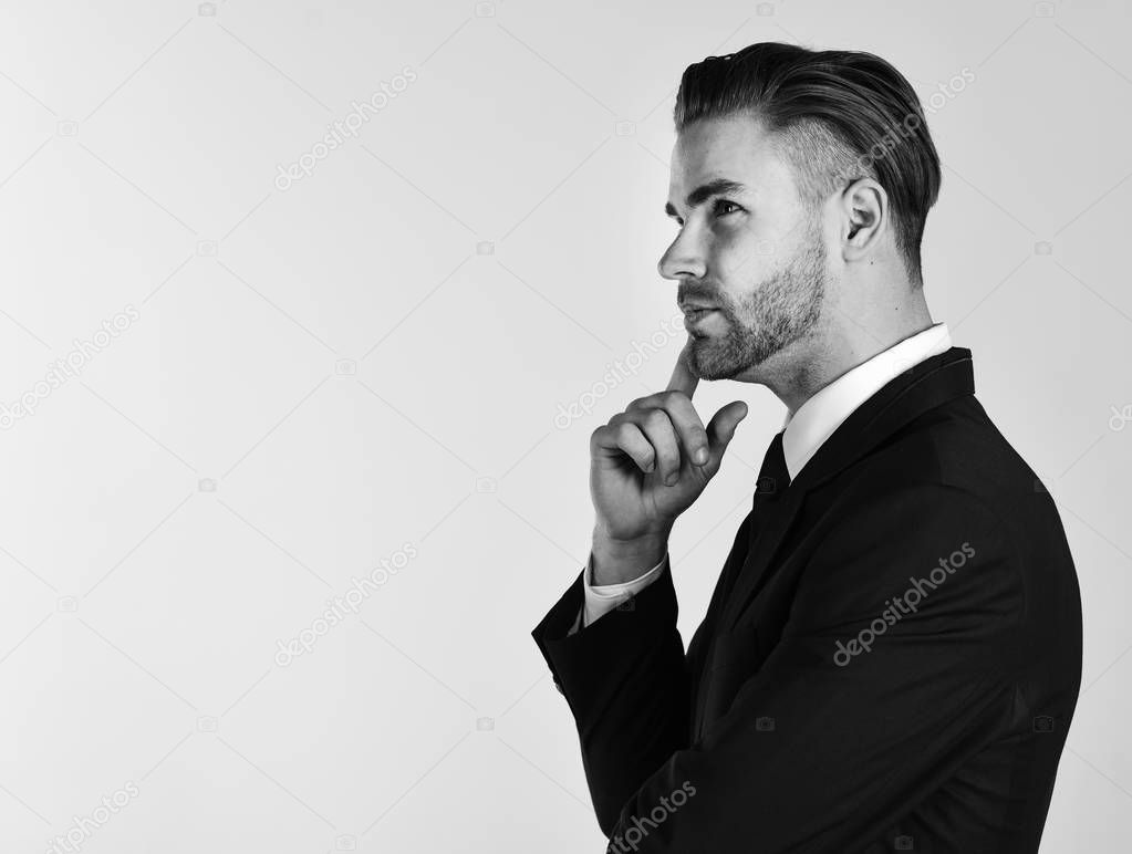 Making decisions concept. Man in suit or businessman with thoughtful face on grey