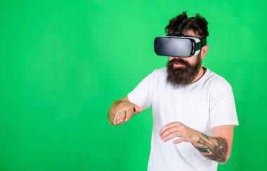 Vr gözlük, yeşil arka planda sakallı adam. Hipster meşgul yüzündeki eğlence ya da eğitim için modern teknolojiler kullanın. Vr gözlüklü Guy Dj karıştırma konsol ile müzik çal. VR müzisyen kavramı