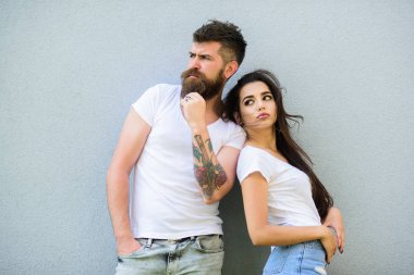 Çift şık genç modern insanlar. Aşık çift birlikte gri duvar arka plan asmak. Kentsel sevgi dolu çift. Çift beyaz gömlek birbirlerine dikkat ediniz. Hipster sakallı ve şık bir kız açık havada takılmak