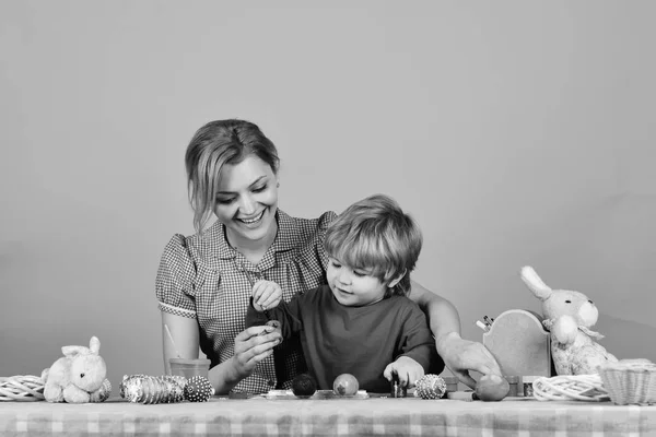 Aile tatil pembe bir arka plan üzerinde hazırlar. Paskalya ve mutlu anları kavramı. Anne ve oğlu resim yumurta — Stok fotoğraf