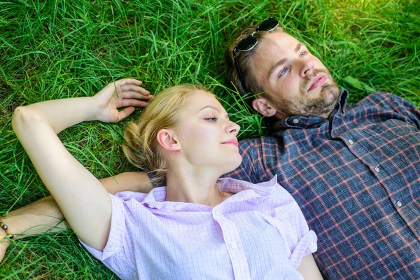 L'homme non rasé et la fille gisaient sur la prairie d'herbe. Plus proche de la nature. Guy et fille heureux insouciant profiter de la fraîcheur de l'herbe. Couple en amour détente reposaient à la prairie. La nature les remplit de fraîcheur et de paix — Photo