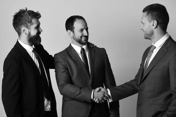 Erkeklerin sakal ve gülümseyen yüzler ile başarılı anlaşmayı yap. CEO'ları, açık gri renkli el sıkışın. İş ve uzlaşma — Stok fotoğraf