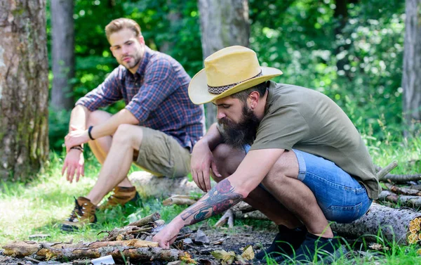 Conceito de masculinidade. Guia final para fogueiras. Como fazer fogueira ao ar livre. Homem brutal hipster barbudo prepara fogueira na floresta. Organizar os galhos da floresta ou paus de madeira. Homens de férias — Fotografia de Stock