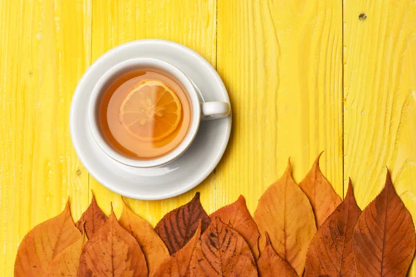 Theekopje met droge bladeren die herfstsamenstelling maken — Stockfoto