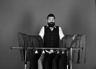 Giysi raf tarafından sakallı adam. Gri takım elbise ceket yakınındaki işadamı ile karışık yüz tutan