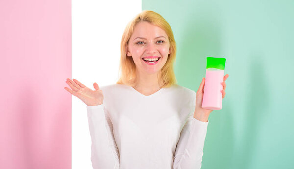 Как быстро и безопасно восстановить отбеленные волосы. Блондинка держит бутылку шампуня. Мой секрет ухода за волосами. Женщина показывает косметический продукт для волос. Косметический продукт. Экспертные советы достичь невероятные волосы
