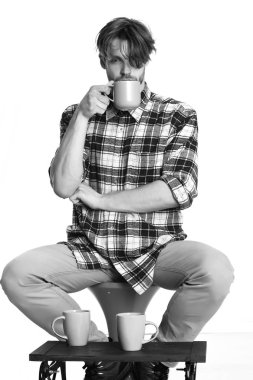 Beyaz arka planda izole edilmiş bardakları tutan yakışıklı adam.