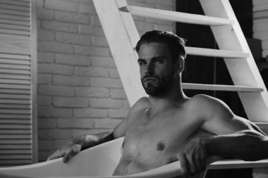 Gevşeme ve erotik bir kavram. Çıplak ve rahatlatıcı küvet, seçici odak içinde oturan maço