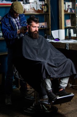 Hippi saç modeli kavramı. Hipster istemci Başlarken saç kesimi. Kuaför saç kesme makinesi ile sakallı adam berber arka plan saç kesimi üzerinde çalışır. İstemci ense üzerinde kırpma makası kesme saçlı berber